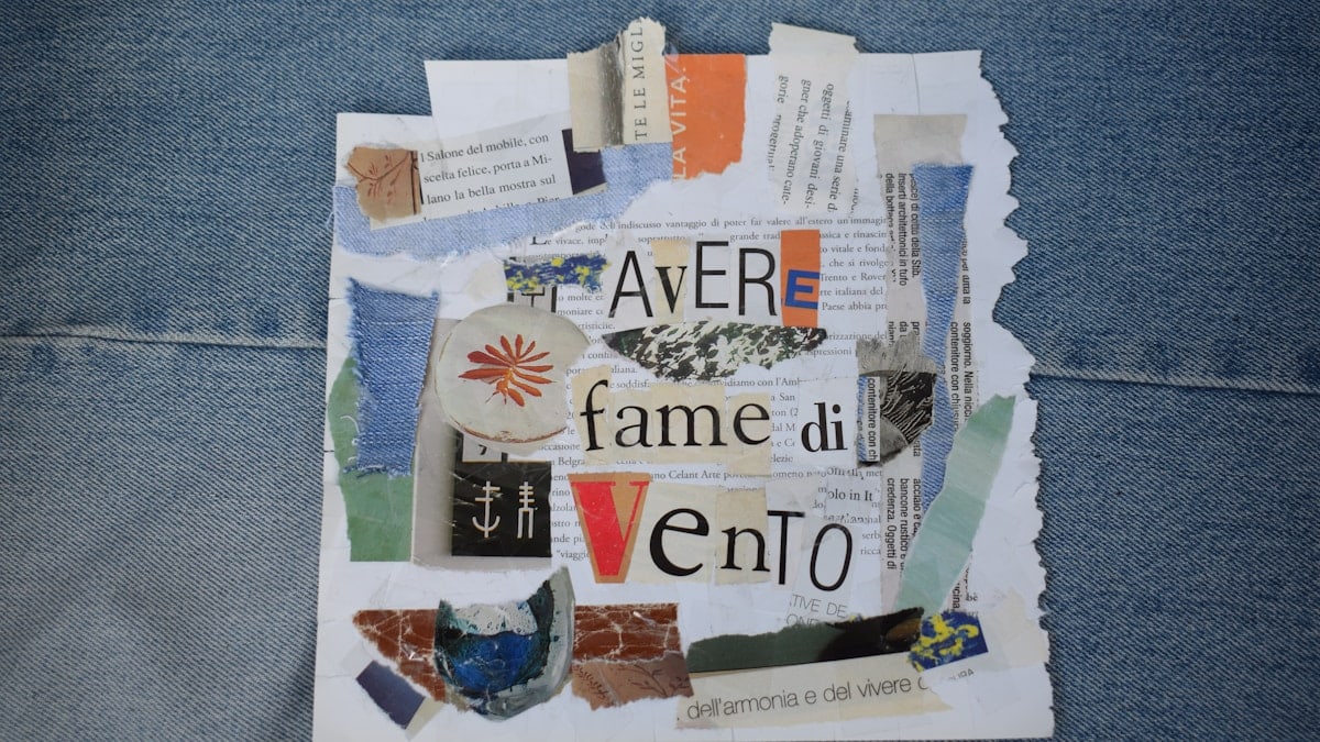 A collage with text "avere fame di vento" on denim.